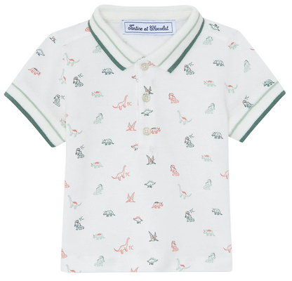 The Tartine et Chocolat Baby Boys’ and Boys’ Knitted Polo Shirt is a white short-sleeve polo crafted from soft cotton, featuring green trim, a small multicolored dinosaur pattern, a buttoned collar, and an inner label with the brand name.