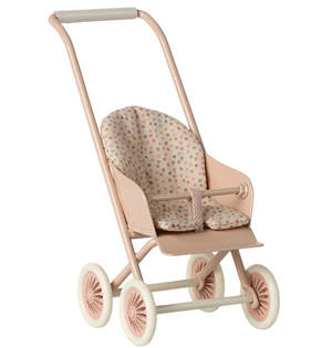 The Maileg Powder Stroller - Micro features a light pink frame with four white wheels, a padded seat accented by a subtle dotted pattern, a safety bar, and an easy-grip handlebar—ideal for carrying micro-sized bunnies or other miniature stroller companions.