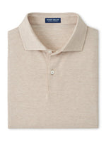A folded beige short-sleeve Excursionist Flex Herringbone Knit Polo by Peter Millar with a collar and two buttons, featuring the brand’s label on the inside neck and crafted from soft cotton jersey knit.