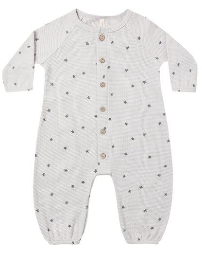 The Quincy Mae Baby Boys’ Waffle Long Sleeve Jumpsuit, shown flat on a white background, features a cozy waffle knit fabric with a subtle small star pattern, front button closure, and elasticized cuffs.