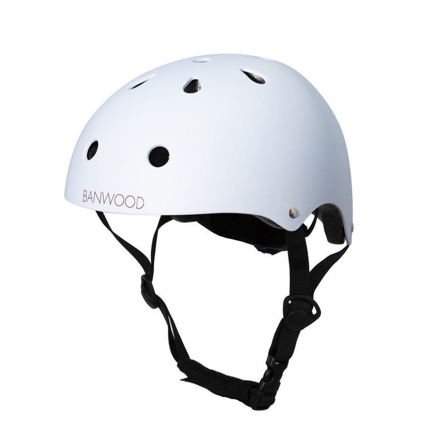 The Banwood Children’s Helmet is white, made from durable ABS hard-shell with ventilation holes and an adjustable chin strap, shown against a white background.
