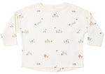 The Quincy Mae Baby and Kids’ Long Sleeve Tee is crafted from organic brushed cotton in classic white and showcases a delightful pattern of small mushrooms, flowers, and rabbits in soft beige and brown hues. Designed with practical shoulder snaps, this comfortable long-sleeve shirt makes dressing easy while keeping your little one cozy all day.