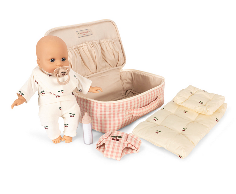 The Konges Slojd Baby Doll Nursery Suitcase includes a soft doll, pacifier, bottle, pink checkered suitcase, and nursery accessories for imaginative play.