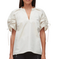 A woman wears the Ruched Sleeve V-Neck Top by 3.1 Phillip Lim, featuring a loose fit in light beige technical poplin with ruched sleeves tied with strings and a deep V neckline.
