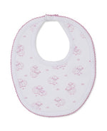 The Kissy Kissy Sweet Sheep Bib, crafted from the softest Pima cotton for exceptional comfort, features a charming pink sheep pattern and pink trim on a white background, and is shown laid flat against a white surface.