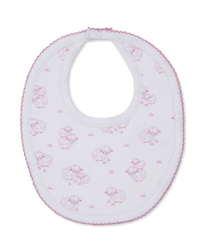 The Kissy Kissy Sweet Sheep Bib, crafted from the softest Pima cotton for exceptional comfort, features a charming pink sheep pattern and pink trim on a white background, and is shown laid flat against a white surface.