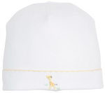 Introducing the Kissy Kissy Premier Giraffe Love Hand Emb. Hat—a white baby hat made from soft Peruvian cotton, featuring a delicately hand-embroidered yellow giraffe and a charming yellow scalloped edge near the bottom.