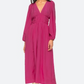 A woman wears the Sea NY Fabiola Dress, a magenta midi with long sleeves, deep v-neckline, gathered waist, and elegant puff sleeves.