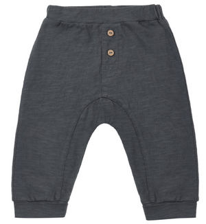 The Rylee & Cru Baby Boys’ Cru Pant features a relaxed fit in dark gray, designed with an elastic waistband, two wooden buttons at the front, and ribbed ankle cuffs. The fabric showcases a subtle textured pattern, making it comfortable and stylish for babies or toddlers.