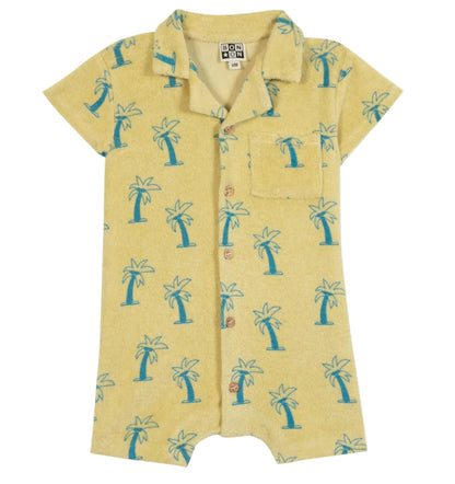 The BTN Lilo Onesie by Bonton is a vibrant yellow short-sleeve romper featuring a blue palm tree print, front buttons, collar, and chest pocket—expertly crafted from soft cotton for all-day comfort.
