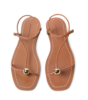 The Lara Sandal by Loeffler Randall features timber brown nappa leather, thin straps, gold-tone spherical accents, and white edge stitching.
