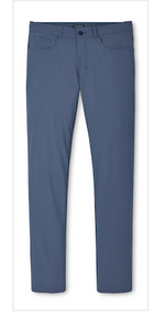 The Peter Millar Bingham Performance Five-Pocket Pant is a pair of blue slim-fit pants crafted from premium Italian knit fabric with four-way stretch, featuring both front and back pockets and shown laid flat on a white background.