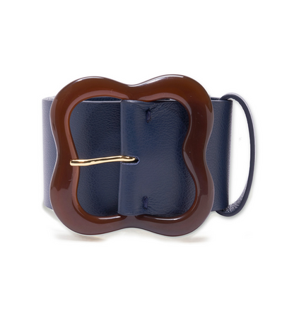 The Lizzie Fortunato Florence Belt boasts a wide, navy blue leather strap paired with an elegantly chic, clover-inspired brown buckle adorned with a gold pin.