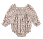 The Baby Girls’ Adelaide Romper by Rylee & Cru features long sleeves, a floral print, smocked detailing on the chest, and ruffled cuffs and neckline, displayed flat against a white background.