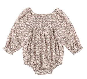 The Baby Girls’ Adelaide Romper by Rylee & Cru features long sleeves, a floral print, smocked detailing on the chest, and ruffled cuffs and neckline, displayed flat against a white background.