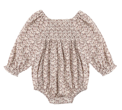 The Baby Girls’ Adelaide Romper by Rylee & Cru features long sleeves, a floral print, smocked detailing on the chest, and ruffled cuffs and neckline, displayed flat against a white background.