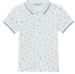 Introducing the Boys’ Polo Shirt by Tartine et Chocolat: a short-sleeved white polo for kids, adorned with a subtle dinosaur pattern, finished with contrasting green trim on the collar and sleeves, and featuring a classic three-button placket.
