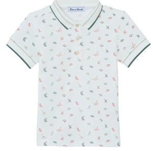 Introducing the Boys’ Polo Shirt by Tartine et Chocolat: a short-sleeved white polo for kids, adorned with a subtle dinosaur pattern, finished with contrasting green trim on the collar and sleeves, and featuring a classic three-button placket.
