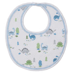 The Kissy Kissy Dinosaur Era Bib is a soft white Pima cotton baby boy bib with blue trim, decorated with cute blue and green cartoon dinosaurs and small trees.