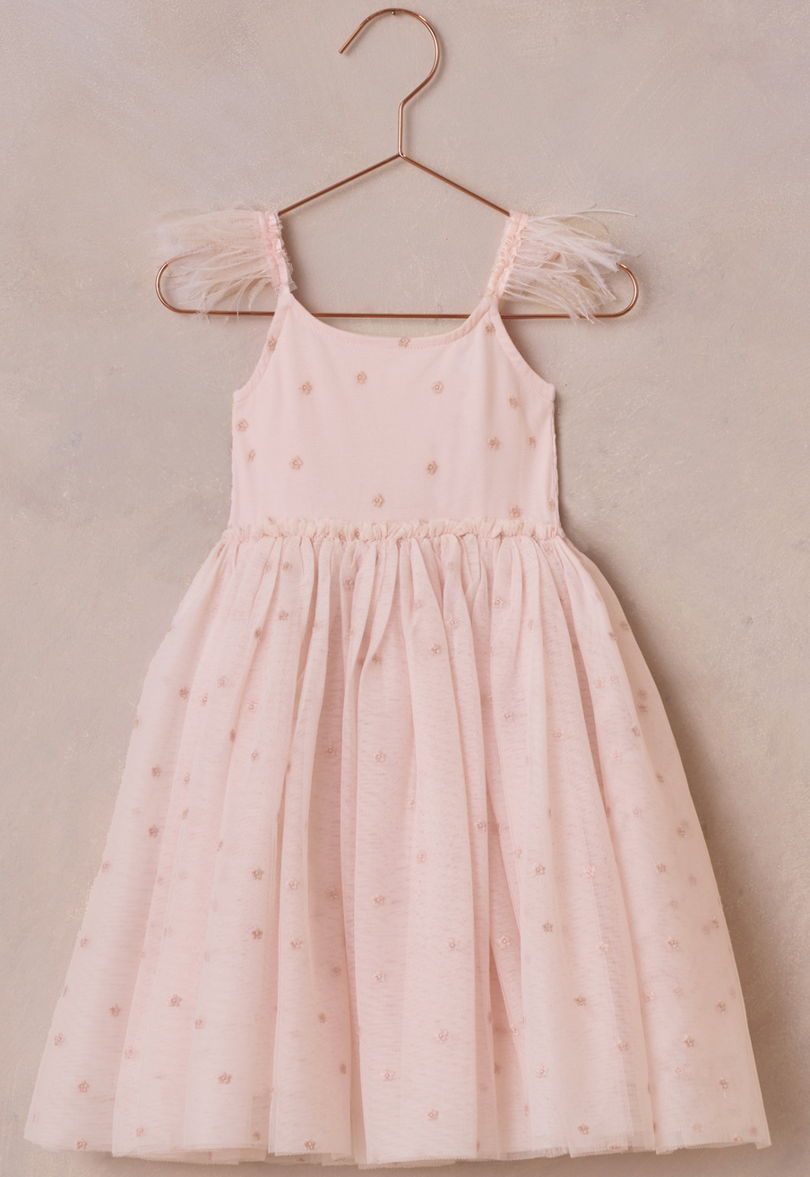 The Noralee Girls' Poppy Dress features light pink tulle with small embroidered dots and sheer ruffled shoulder straps, shown on a rose gold hanger against a neutral background.