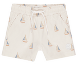 The Rylee & Cru Boys' Board Short features a beige sailboat pattern, elastic waistband, white drawstring, and a small circular logo—ideal for coordinated swimwear moments with siblings or friends.