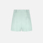 The Zenith Selle Shorts by Blaze Milano feature a light blue hue, high waist, belt loops, and a subtle stitched detail on the right side—exuding refined tailoring for your 2026 resort looks. Shown against a plain white background.