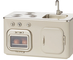 Maileg’s Kitchen - Miniature is a beige toy kitchen set inspired by classic metal kitchens, featuring a stovetop, oven with pretend food, sink, and cabinet—perfect for adding realism to your dollhouse or pairing with Maileg mice.