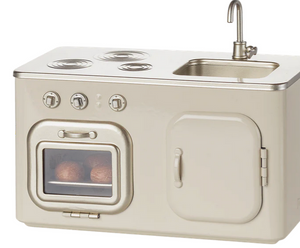 Maileg’s Kitchen - Miniature is a beige toy kitchen set inspired by classic metal kitchens, featuring a stovetop, oven with pretend food, sink, and cabinet—perfect for adding realism to your dollhouse or pairing with Maileg mice.