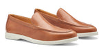 The Excursionist Leather Venetian Loafer by Peter Millar in light brown leather features white rubber soles. This pair of lightweight Brazilian loafers is displayed at a slight angle on a plain background.