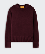 The Cozy Crew Cashmere Sweater by Guest in Residence is a long-sleeve, dark burgundy knit featuring a cozy crew neckline, ribbed cuffs, hem, and collar, and a relaxed dropped shoulder design, shown against a plain light background.