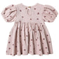 The Quincy Mae Baby Girls' and Girls' Darla Dress is a light pink babydoll with puffed short sleeves, a gathered skirt, brown heart prints, and a back button closure.