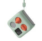 A compact, square, mint-green Yoto Player Mini device featuring two orange dials, a speaker, a black screen, and a lanyard attachment—ideal for pairing with the Yoto Player Mini Adventure Jacket by Yoto or a silicone carry-case for added protection while on the move.