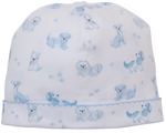 The Kissy Kissy Puppy Paws Printed Hat is a white baby hat crafted from soft Pima cotton, featuring light blue dog and puppy paw print patterns, with a stitched blue seam near the brim.