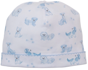 The Kissy Kissy Puppy Paws Printed Hat is a white baby hat crafted from soft Pima cotton, featuring light blue dog and puppy paw print patterns, with a stitched blue seam near the brim.