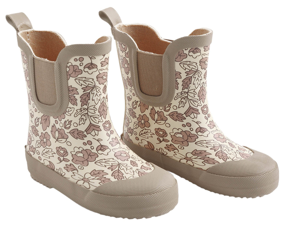 A pair of Quincy Mae Rain Boots in beige, featuring a brown floral and leaf pattern, reinforced toes, pull tabs at the back, and a comfortable rubber lining for enhanced durability.
